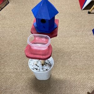 Handmade outdoor wooden bird house with feeder on a wooden pole